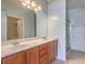 Bathroom with double sinks, wood cabinets, and a glass-enclosed shower at 5960 Wheat Penny Ave, Las Vegas, NV 89122
