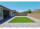 Wide backyard with artificial turf, brick walls, and an outdoor grill at 6250 Lamont Hills Ave, Las Vegas, NV 89139