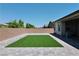A home backyard with a rectangular patch of artificial grass and paved patio at 6250 Lamont Hills Ave, Las Vegas, NV 89139