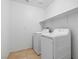 Functional laundry room equipped with a washing machine, dryer, and storage shelf for convenience at 6354 Point Isabel Way, Las Vegas, NV 89122