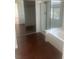 Bathroom featuring a glass-enclosed shower, soaking tub, and wood-look flooring at 7228 Chic Ave, Las Vegas, NV 89129