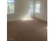 Spacious bedroom with plush carpeting and multiple windows providing ample natural light at 7228 Chic Ave, Las Vegas, NV 89129