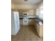 Kitchen area equipped with white appliances, ample cabinets, and tile flooring at 7228 Chic Ave, Las Vegas, NV 89129