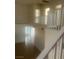 An upper level hallway with staircase and views to the lower level, designed with neutral paint and bright light at 7228 Chic Ave, Las Vegas, NV 89129
