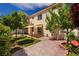 Inviting backyard with a covered patio, brick paving, lush greenery, and a well-maintained lawn, perfect for outdoor living at 7924 Horn Tail Ct, Las Vegas, NV 89131