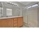 Bathroom featuring double sinks, oak cabinets and a glass-enclosed shower at 7924 Horn Tail Ct, Las Vegas, NV 89131