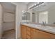 Bathroom with double sinks, oak cabinets, and vanity lighting at 7924 Horn Tail Ct, Las Vegas, NV 89131