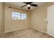 Bedroom featuring plush carpeting, a large window with views, and a ceiling fan at 795 Kiska Ave, Las Vegas, NV 89123