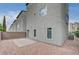 A rear view of the property shows the small yard, and the neutral stucco exterior finish and a paver stone patio at 8056 Haywood Estate Ave, Las Vegas, NV 89113