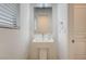 Modern bathroom featuring a sleek pedestal sink, a large mirror, and a tiled wall at 8056 Haywood Estate Ave, Las Vegas, NV 89113