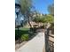 A sidewalk and seating area is near the grassy and landscaped section of the community recreation area at 8056 Haywood Estate Ave, Las Vegas, NV 89113