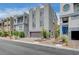 Modern townhomes feature desert landscaping, brick-paved driveways, and gray concrete exteriors under a partly cloudy sky at 8056 Haywood Estate Ave, Las Vegas, NV 89113