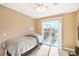 Bright bedroom featuring light-colored walls, ceiling fan, plush carpet, and a sliding glass door to the balcony at 824 Schooner Dr, Henderson, NV 89015