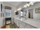 Well-lit bathroom with double sinks, a large mirror, and a window for natural light at 8388 Brad Oaks Cir, Las Vegas, NV 89123