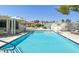 Community pool with clear blue water and lounge chairs for relaxation on a sunny day at 8388 Brad Oaks Cir, Las Vegas, NV 89123