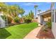 Lush backyard with artificial turf, mature trees, a built-in hot tub, and a cozy covered patio at 8723 Melissa Meadows St, Las Vegas, NV 89131
