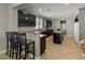 A kitchen with dark cabinetry, recessed lighting, and granite countertops and island with barstool seating at 8723 Melissa Meadows St, Las Vegas, NV 89131