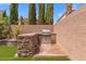 An outdoor kitchen area has a stone counter, stainless steel grill, and a concrete patio at 8723 Melissa Meadows St, Las Vegas, NV 89131