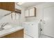 Efficient laundry room with a utility sink, cabinets, and a washer and dryer at 8921 Signal Terrace Dr, Las Vegas, NV 89134