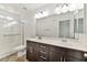 Bright bathroom featuring dual sinks, framed mirror, shower over bath and wood cabinets at 9050 W Tropicana Ave # 1075, Las Vegas, NV 89147