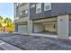 Modern townhouse featuring a two-car garage with an open door and exterior lighting at 9050 W Tropicana Ave # 1075, Las Vegas, NV 89147