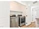 Bright laundry room with modern washer and dryer, shelving, and white trim at 9050 W Tropicana Ave # 1075, Las Vegas, NV 89147