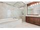 Luxurious bathroom featuring a soaking tub, glass enclosed shower, and & vanities with granite counters at 9101 Alta Dr # 1604, Las Vegas, NV 89145