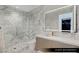Modern guest bathroom with marble walls, glass shower, and sleek vanity at 9101 Alta Dr # 1604, Las Vegas, NV 89145