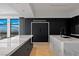 Modern kitchen with sleek black refrigerator and marble waterfall countertops with a great view at 9101 Alta Dr # 1604, Las Vegas, NV 89145