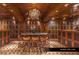 Spacious wine cellar with custom wood cabinetry, chandelier, and table with seating for eight at 9101 Alta Dr # 1604, Las Vegas, NV 89145