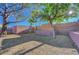 Backyard features a brick retaining wall and lush shade trees at 9398 Sailing Water Ave, Las Vegas, NV 89147