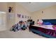 Bedroom with a sloped ceiling, plush carpet, a double bed and an office desk, providing a comfortable personal space at 9398 Sailing Water Ave, Las Vegas, NV 89147