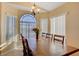 Dining area featuring an elegant chandelier, large windows with blinds, and seating for six at a wooden table at 9398 Sailing Water Ave, Las Vegas, NV 89147