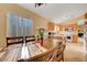 Bright dining area with a wooden table, seating for six, a vase of flowers, and a view of the kitchen at 9398 Sailing Water Ave, Las Vegas, NV 89147