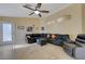 A spacious living room with tile flooring, a ceiling fan, and a comfortable, oversized sectional sofa at 9398 Sailing Water Ave, Las Vegas, NV 89147