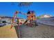 Backyard playground area featuring a wooden play structure with swings and a slide, fun for  at 9398 Sailing Water Ave, Las Vegas, NV 89147