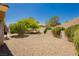 Spacious backyard featuring desert landscaping, mature trees and a stone retaining wall for added privacy at 9525 Salem Hills Ct, Las Vegas, NV 89134