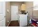 Functional laundry room with washer, dryer, storage shelves, and convenient access at 9525 Salem Hills Ct, Las Vegas, NV 89134