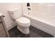 Modern bathroom with a white toilet, sleek black fixtures, and stylish black marble tile at 9604 Flying Eagle Ln, Las Vegas, NV 89123