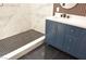 Renovated bathroom with stylish blue vanity, black marble floors, and walk-in shower at 9604 Flying Eagle Ln, Las Vegas, NV 89123