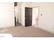 A minimalist bedroom with neutral carpet and contrasting doors leading to the closet and other rooms at 9604 Flying Eagle Ln, Las Vegas, NV 89123