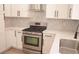 Modern white kitchen featuring stainless steel appliances and quartz countertops at 9604 Flying Eagle Ln, Las Vegas, NV 89123