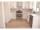 Modern kitchen with white cabinets, stainless steel appliances, and a stylish herringbone backsplash at 9604 Flying Eagle Ln, Las Vegas, NV 89123