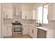 Modern white kitchen featuring stainless steel appliances and quartz countertops at 9604 Flying Eagle Ln, Las Vegas, NV 89123