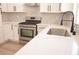 Modern white kitchen featuring stainless steel appliances and quartz countertops at 9604 Flying Eagle Ln, Las Vegas, NV 89123