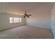 Bright bedroom with neutral carpet, ceiling fan, and sunny window at 9728 Panther Hollow St, Las Vegas, NV 89141