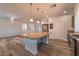 Kitchen showcasing a central island with pendant lighting, stainless appliances, and dark wood cabinetry at 9728 Panther Hollow St, Las Vegas, NV 89141
