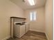 A functional laundry room equipped with a washer, dryer, and overhead shelving at 9728 Panther Hollow St, Las Vegas, NV 89141