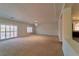 A large living room featuring plush carpet, recessed lighting, and plentiful natural light at 9728 Panther Hollow St, Las Vegas, NV 89141