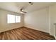 An airy bedroom with sleek, modern floors, a ceiling fan, and a large window for ample natural light at 9748 Derbyhill Cir, Las Vegas, NV 89117